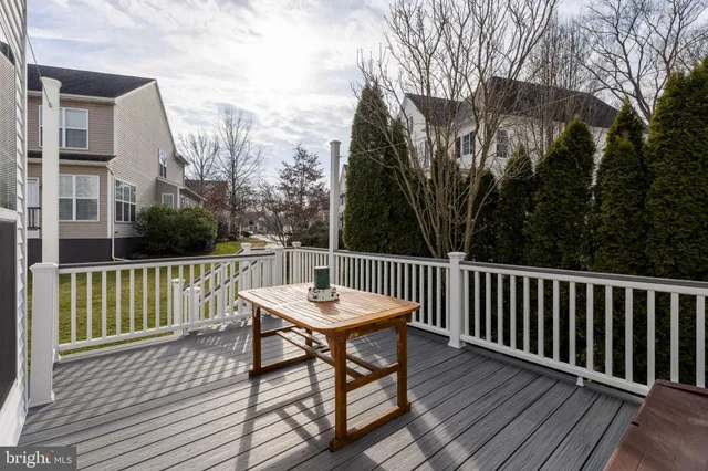 a view of a white house next to a yard with big trees