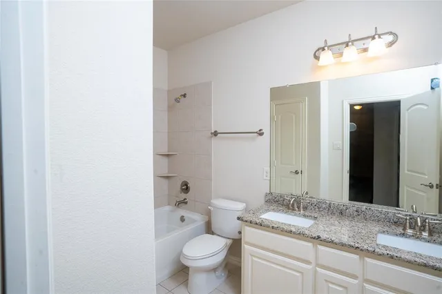 a bathroom with a granite countertop sink toilet and mirror