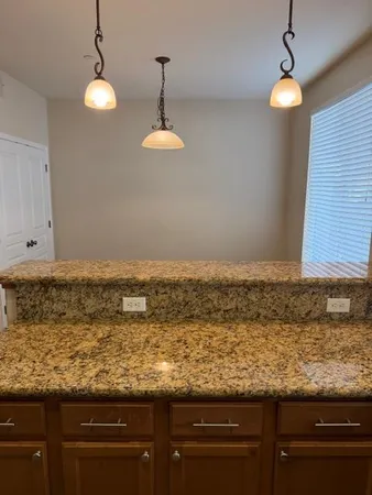 a view of a room with wooden floor and chandelier