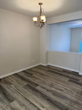 a view of a room with wooden floor and chandelier