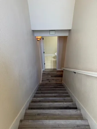 a view of a hallway with wooden floor and staircase