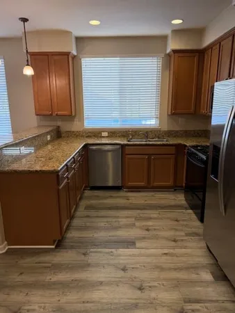 a kitchen with stainless steel appliances granite countertop a sink stove and refrigerator