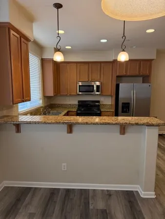 a kitchen with kitchen island granite countertop wooden cabinets and a stainless steel appliances
