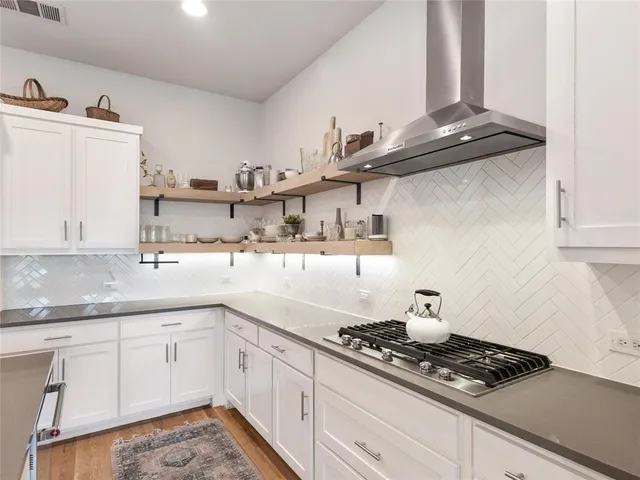 a kitchen with stainless steel appliances granite countertop a sink stove and cabinets