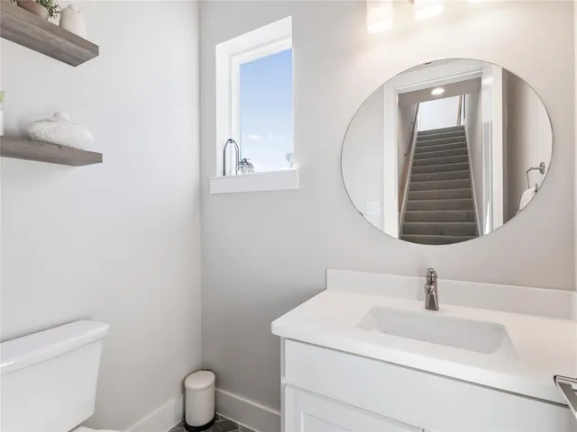 a bathroom with a toilet a sink and mirror