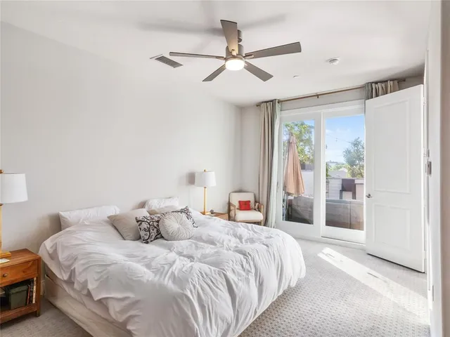 a bedroom with a large bed and a ceiling fan