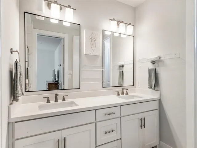 a bathroom with double sink and a mirror