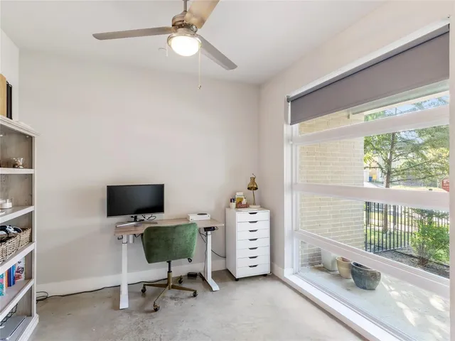 a view of a workspace with furniture and a window