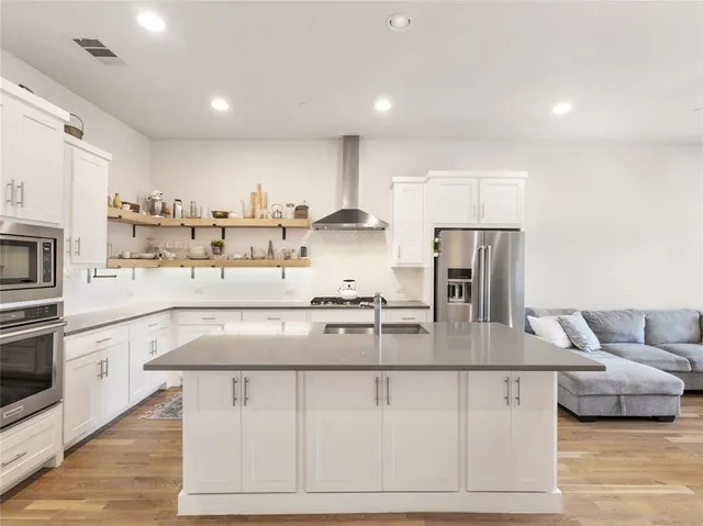 a kitchen with stainless steel appliances granite countertop a sink and a refrigerator