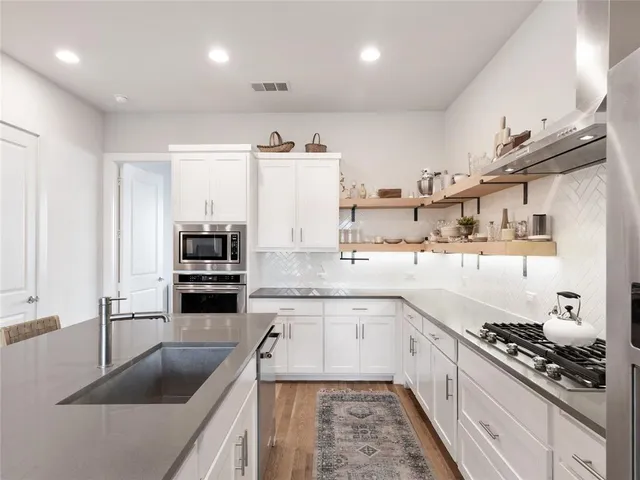 a kitchen with stainless steel appliances kitchen island granite countertop a sink stove and cabinets