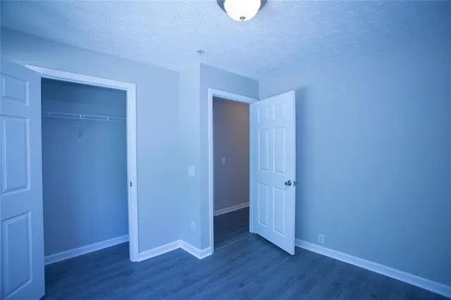 an empty room with wooden floor and closet