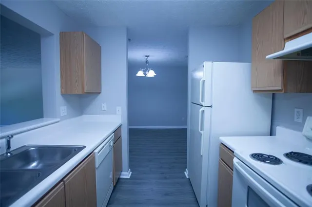 a kitchen that has a sink a refrigerator and a stove