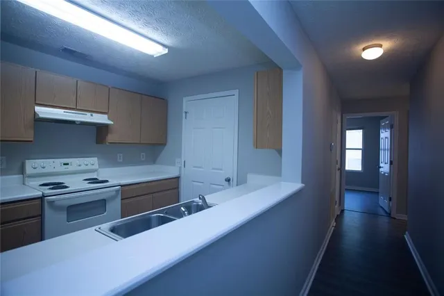 a kitchen with stainless steel appliances granite countertop a sink stove and cabinets