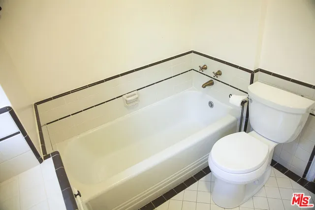 a white toilet sitting next to a bath tub