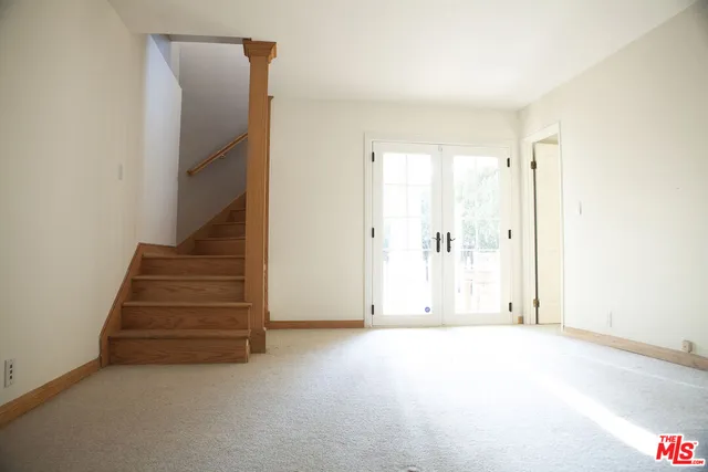 an empty room with staircase and white walls