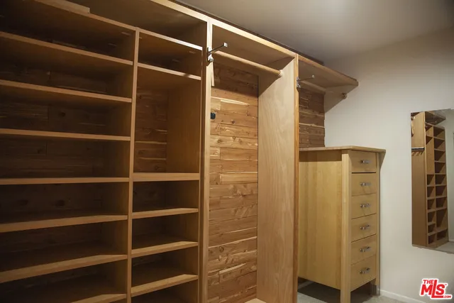 a view of walk in closet with empty racks