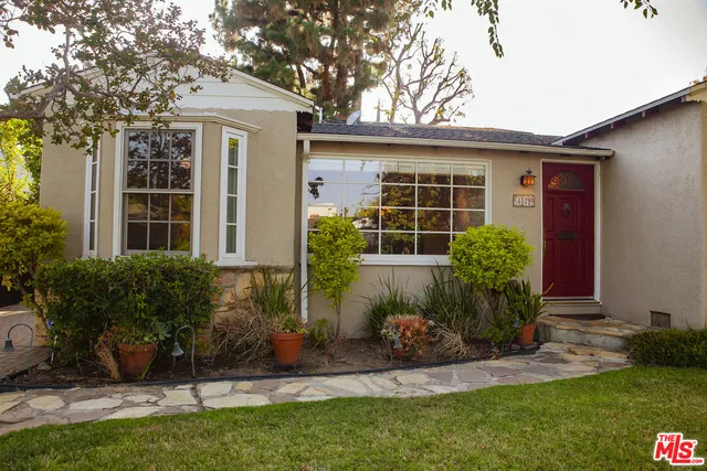 a front view of a house with a yard and potted plants