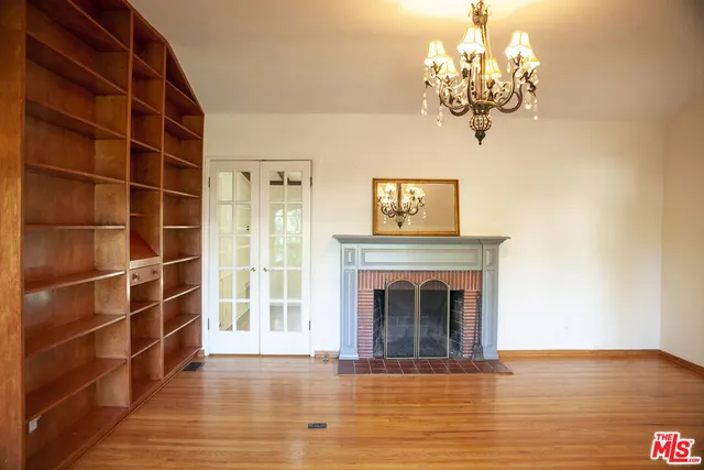 a view of a livingroom with a fireplace wooden floor and a window