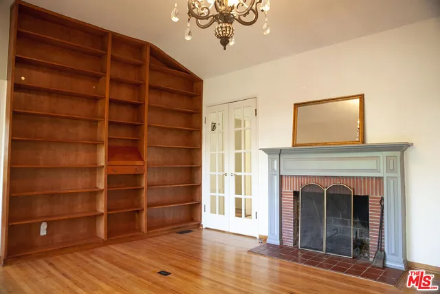 a view of an empty room with a fireplace and a window
