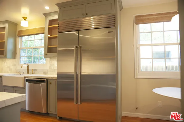 a kitchen with stainless steel appliances granite countertop a refrigerator and a sink
