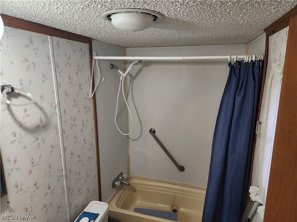 3895 Middletown Road East Youngstown, OH 44514 - Photo 24 of 28 Bathroom with a textured ceiling and shower / bath combo with shower curtain