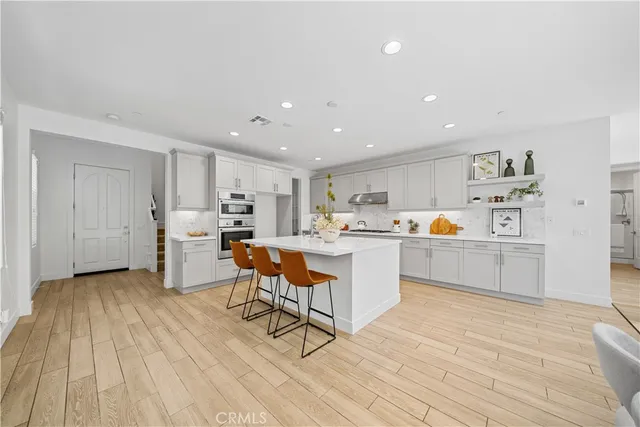 a kitchen with stainless steel appliances a sink dishwasher stove refrigerator and cabinets