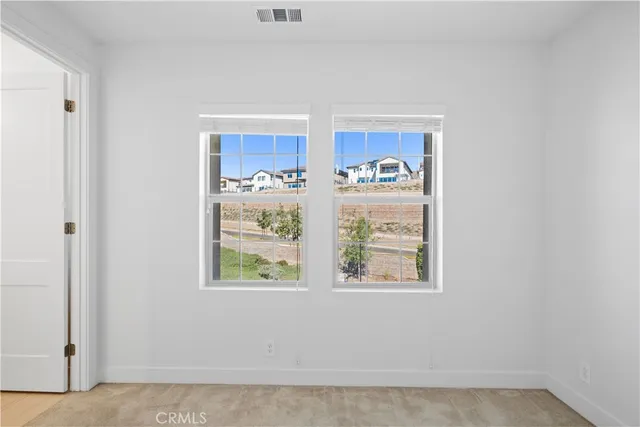 an empty room with a ceiling fan and carpet