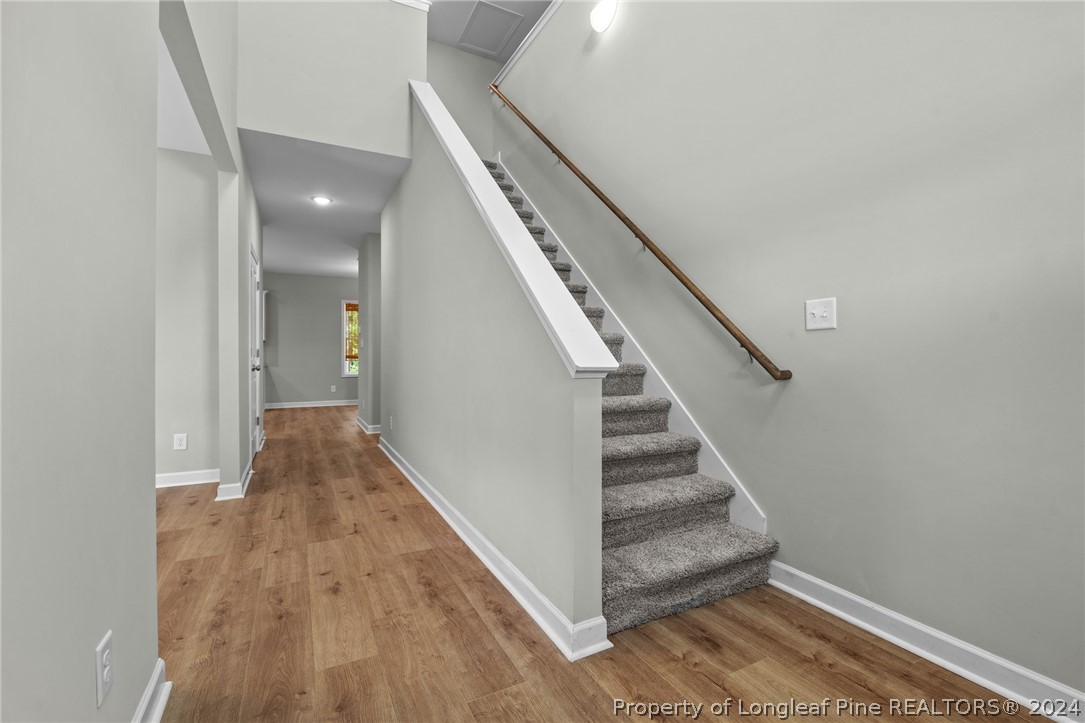 2632 Riddle Farm Road Fayetteville, NC 28306 - Photo 9 of 45 a view of a hallway with wooden floor and staircase
