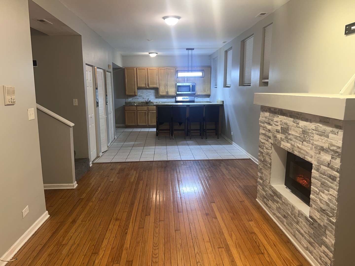 1430 East 69th Street, Unit 1S Chicago, IL 60637 - Photo 3 of 16 a kitchen with kitchen island wooden floors appliances and cabinets