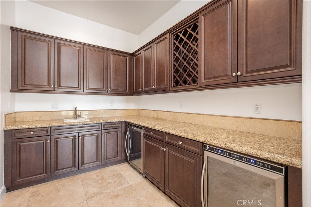 10727 West Stallion Ranch Road Shadow Hills, CA 91040 - Photo 16 of 39 a kitchen with granite countertop cabinets sink and white stainless steel appliances