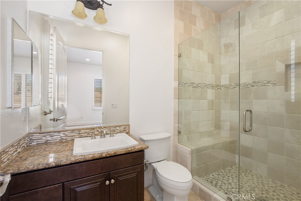 10727 West Stallion Ranch Road Shadow Hills, CA 91040 - Photo 22 of 39 a bathroom with a granite countertop sink a toilet and shower