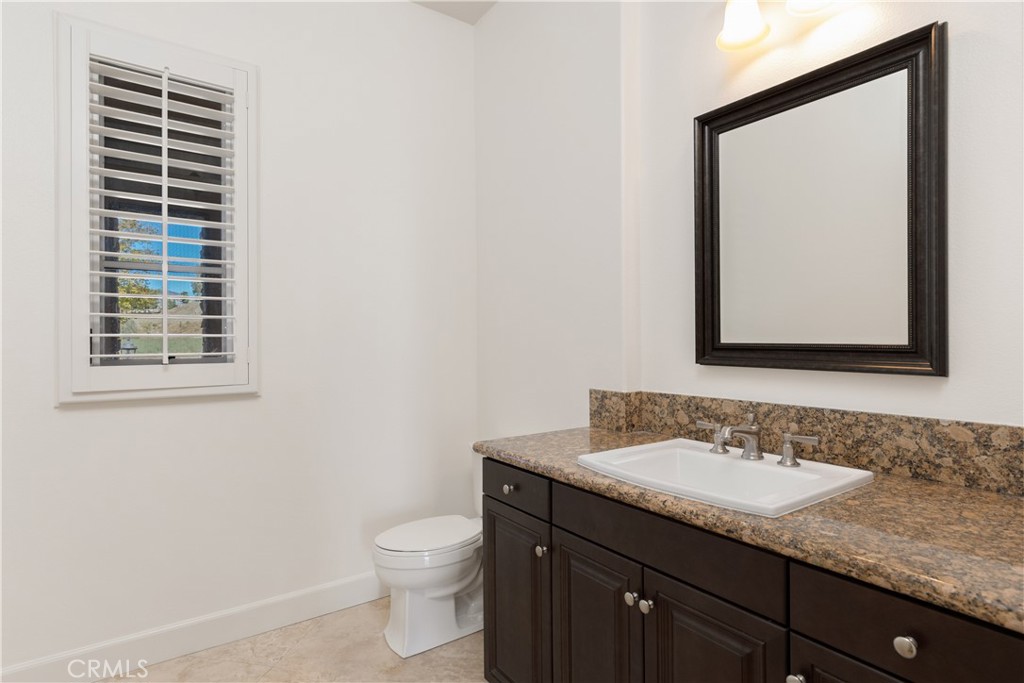 10727 West Stallion Ranch Road Shadow Hills, CA 91040 - Photo 29 of 39 a bathroom with a granite countertop sink toilet and mirror