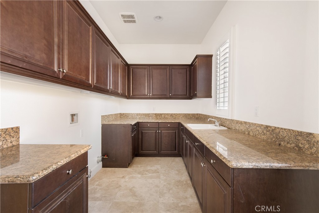 10727 West Stallion Ranch Road Shadow Hills, CA 91040 - Photo 30 of 39 a kitchen with granite countertop a sink and dishwasher a stove top oven with wooden floor