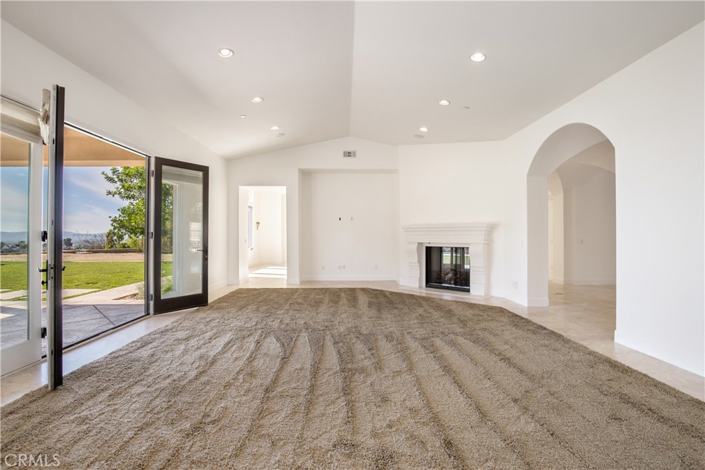 10727 West Stallion Ranch Road Shadow Hills, CA 91040 - Photo 9 of 39 a view of an empty room with a fireplace and a window