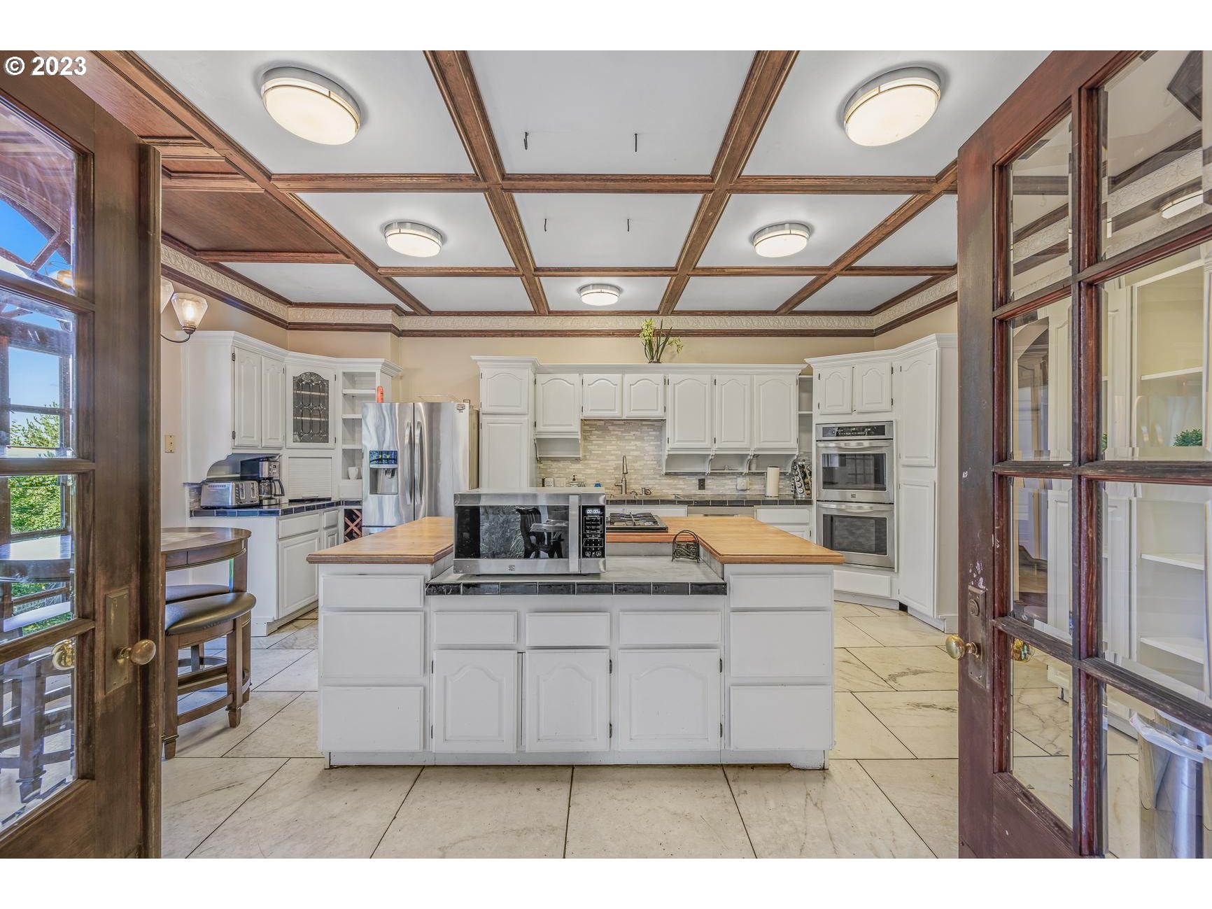 4224 Southwest Melville Avenue Portland, OR 97239 - Photo 16 of 48 a large white kitchen with a large window and stainless steel appliances
