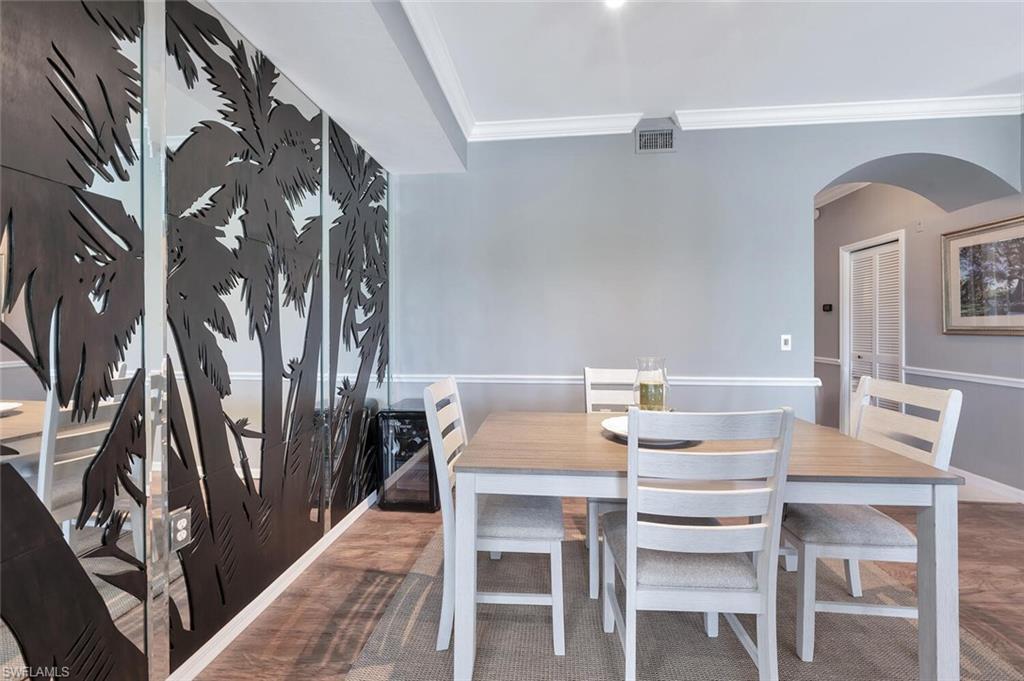 8600 Cedar Hammock Circle, Unit 1313 Naples, FL 34112 - Photo 11 of 48 a view of a dining room with furniture and wooden floor