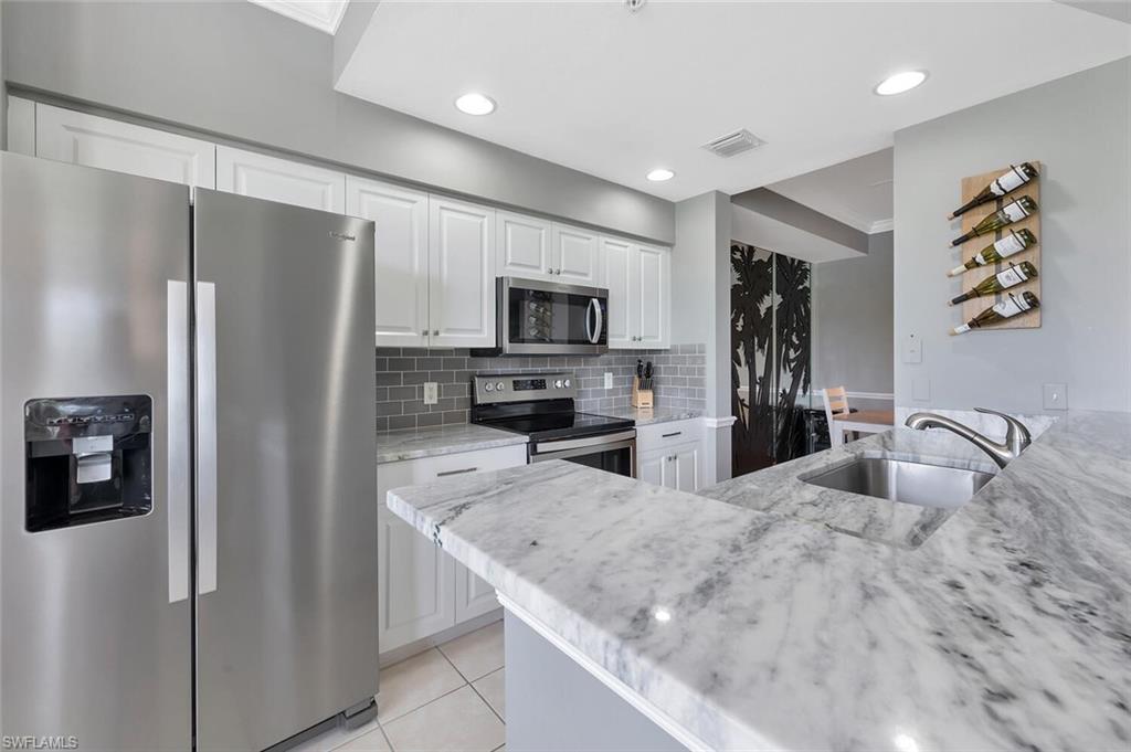 8600 Cedar Hammock Circle, Unit 1313 Naples, FL 34112 - Photo 2 of 48 a kitchen with granite countertop a refrigerator and a sink