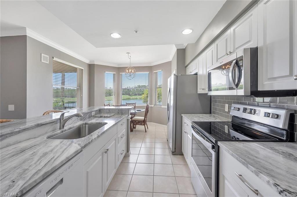 8600 Cedar Hammock Circle, Unit 1313 Naples, FL 34112 - Photo 3 of 48 a kitchen with stainless steel appliances granite countertop a sink stove and refrigerator