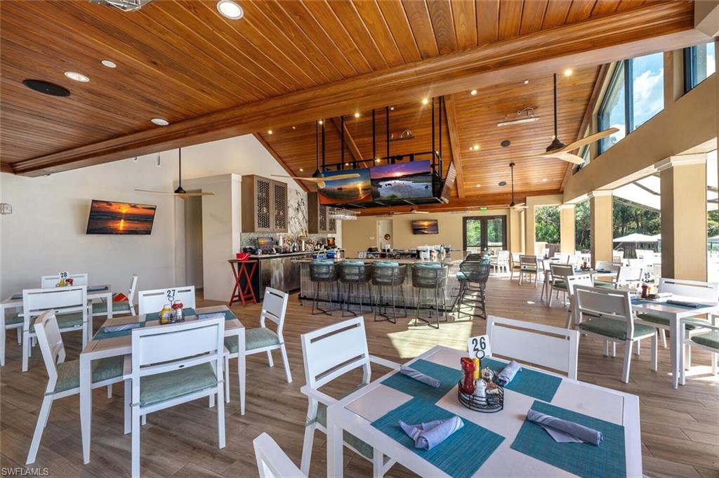 8600 Cedar Hammock Circle, Unit 1313 Naples, FL 34112 - Photo 36 of 48 a living room with lots of furniture and a dining table with wooden floor