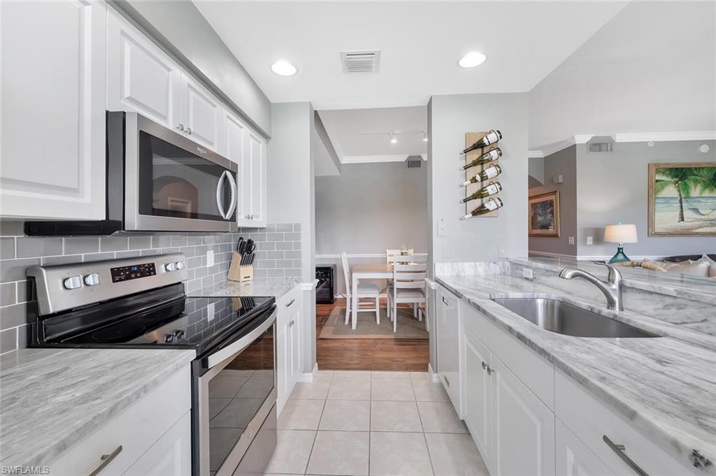 8600 Cedar Hammock Circle, Unit 1313 Naples, FL 34112 - Photo 4 of 48 a kitchen with stainless steel appliances granite countertop a sink stove and microwave