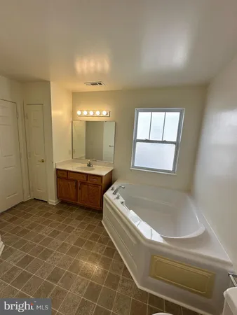 a bathroom with a tub sink and mirror