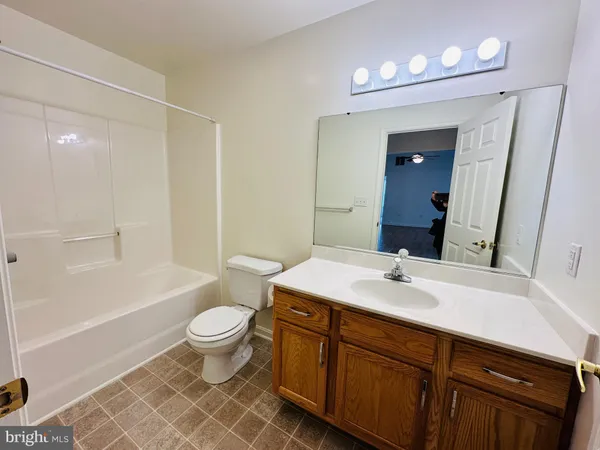 a bathroom with a sink a toilet and a large mirror