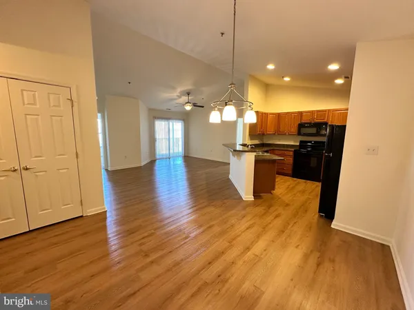 a view of a kitchen with a sink and dishwasher a stove top oven with wooden floor