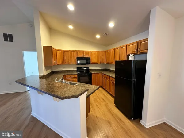 a kitchen with stainless steel appliances granite countertop a refrigerator a stove and a sink