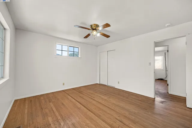 a view of a room with wooden floor and a ceiling fan