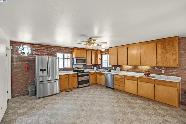 a large kitchen with a large window and stainless steel appliances