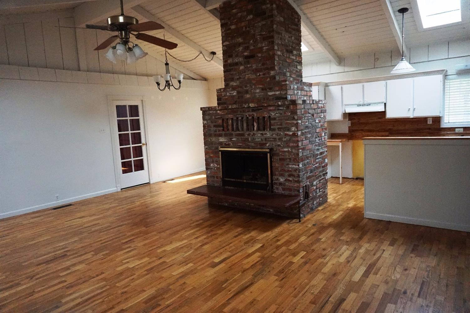 1312 Talent Avenue Talent, OR 97540 - Photo 4 of 21 an empty room with wooden floor fireplace and windows