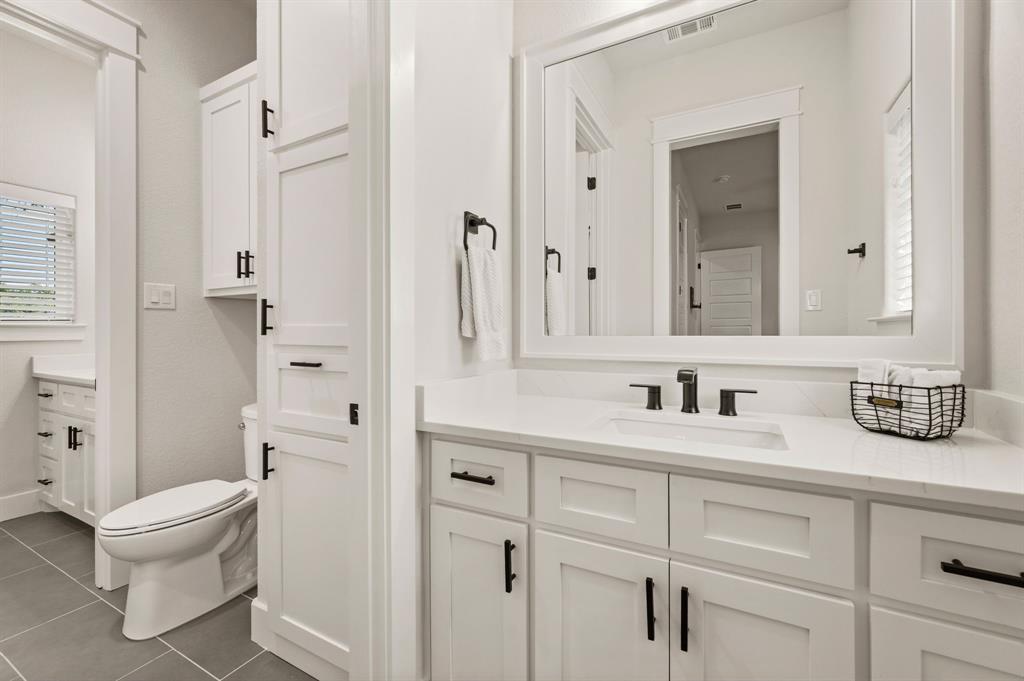 200 Clayton Crossing Springtown, TX 76082 - Photo 26 of 40 a bathroom with a granite countertop sink toilet a mirror and shower