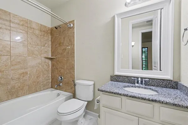 a bathroom with a granite countertop sink a toilet and shower