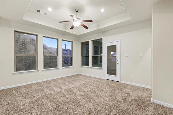 a view of an empty room with a window and a kitchen
